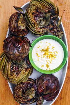 grilled artichokes with ranch dip on a plate