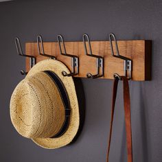 a hat hanging on a coat rack with hooks