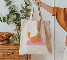 A 100% cotton tote bag is the champion of durability, sustainability, and style. .: Material: 6 oz/yd², 100% natural cotton canvas fabric .: One size: 15" x 16" (38.1cm x 40.6cm) .: Convenient self-fabric handles .: Double-sided print Rectangular Cotton Bag With Cat Design, Cotton Tote Bag With Cat Print, Cotton Bag With Cat Print, Rectangular Shape, Cotton Bags With Cat Print For Everyday Use, Everyday Cotton Bags With Cat Print, Cotton Cat Print Bags For Everyday Use, Rectangular Cotton Bag With Cat Print, Cotton Cat Print Rectangular Bag, Daily Use Cotton Bags With Cat Design