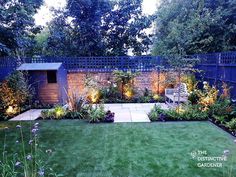 a backyard garden is lit up with lights