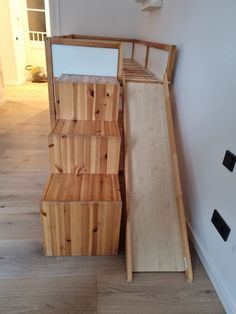 a wooden bench sitting on top of a hard wood floor next to a white wall