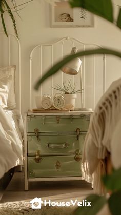 a white bed sitting next to a green chest of drawers