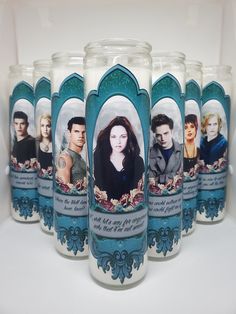 several candles with pictures of people on them are lined up in a row, one is blue and the other is white