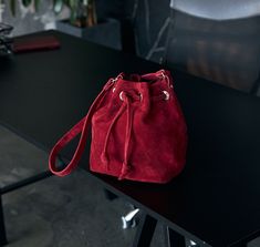 Red Suede Pouch, an elegant and stylish accessory that will add a touch of sophistication to your everyday look. This stunning red suede pouch bag is crafted with precision and care, ensuring top-notch quality and durability. The rich crimson hue exudes a sense of luxury and allure, making it a true statement piece. Perfectly sized to hold your essentials, this pouch is ideal for carrying your phone, keys, wallet, or cosmetics. The soft and velvety texture of the suede adds an extra layer of elegance and comfort. Handmade with love, this red suede pouch is a must-have accessory for any fashion-forward individual. Materials: Red Suede Dimensions: length*height*width 30cm*40cm*10cm The length of the handle is made individually. You can choose the color you want for each bag: - cherry - beige Luxury Red Pouch For Everyday Use, Modern Red Bucket Bag For Formal Occasions, Elegant Suede Bucket Bag, Suede Bag, Vanessa Bruno, Stylish Storage, Red Suede, Coin Purses, Purse Pouch