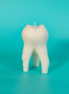 a white toothbrush holder with an apple on the top, against a blue background