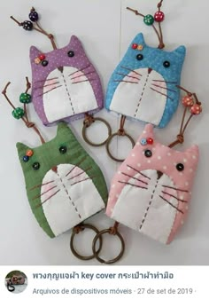 four cat key fobs are on display in front of a tweet