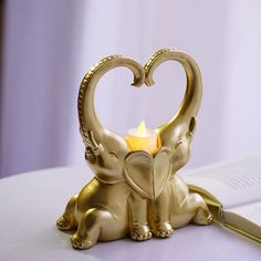 an elephant candle holder sitting on top of a table next to a knife and book