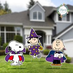 charlie brown and snoopy halloween yard stakers in front of a house with the words happy halloween written on it