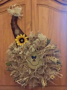 a door with a scarecrow's head and sunflowers on the front