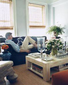 a man sitting on top of a couch in a living room