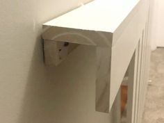 a cat peeking through the corner of a wall