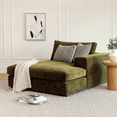 a living room with a green couch and white walls