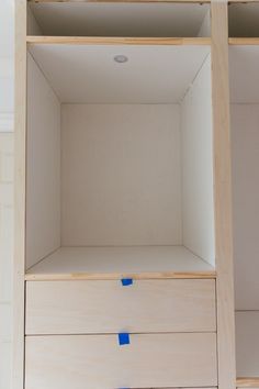 an empty wooden shelf with blue tape on it