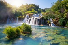 there is a waterfall in the middle of this river and it's blue water