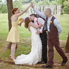 a group of people standing next to each other in front of a tree and grass field