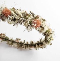 an arrangement of flowers is arranged in the shape of a flower headband on a white background