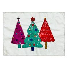 three christmas trees on a white background with red, green and blue decorations in the middle