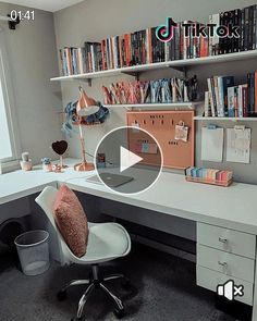 a white desk topped with a computer monitor and a chair next to a book shelf filled with books