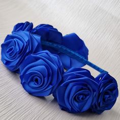 three blue roses sitting on top of a table next to a hair comb and scissors