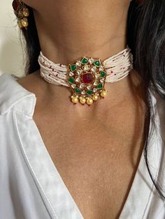 Adorn yourself with this gorgeous Indian Kundan Jewelry piece. You will definitely fall in love with the multicolored Kundan stone brooch at the center and the beautiful pearl strings on both sides.  Notice the pink beads weaved into the pearl strings.  Handmade by our skilled Indian craftsmen from Jaipur.  The statement Kundan studs add to the royalty of the wedding choker.  Material: Silver, Copper mix, gold plating, pearls, multicolored Kundan work. Dimensions Weight of choker is 46 g. Choker Multicolor Jeweled Bridal Necklace For Wedding, Jeweled White Bridal Necklace For Celebration, White Jeweled Bridal Necklace For Celebration, White Jeweled Bridal Necklace For Wedding, Festive White Bridal Necklace With Gemstone, White Multi-stone Jewelry For Celebration, Multicolor Gemstone Bridal Necklace For Wedding, Kundan Studs, Pearl Strings