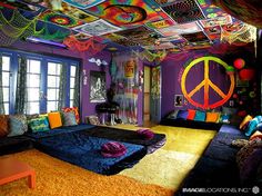 a bedroom decorated in bright colors with peace signs on the ceiling and rugs covering the floor