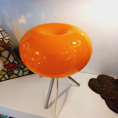 an orange lamp sitting on top of a white table