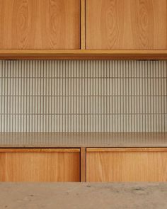 a kitchen counter top with wooden cabinets and tile backsplash in the backround