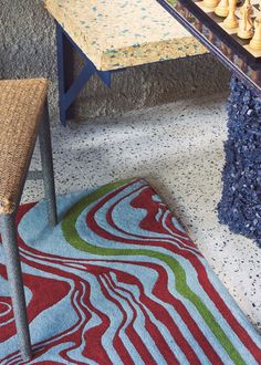 a chess board sitting on top of a rug next to a table