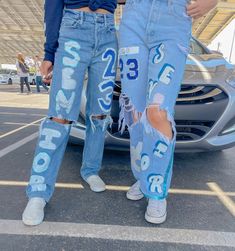 two people standing next to each other in front of a car with the words ford on it