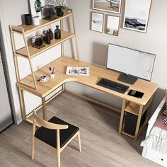 a computer desk with a laptop on top of it next to a chair and bookshelf