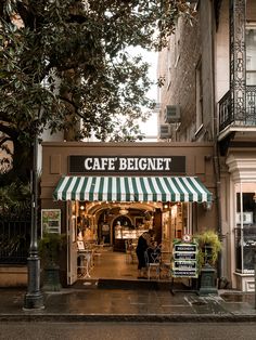 the entrance to cafe beignet in new york city, with green and white awnings