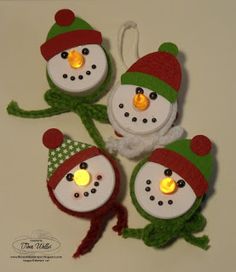 three snowmen with hats and lights are hanging from strings on a wall ornament