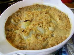 a casserole dish with potatoes and meat in it sitting on a blue and white checkered table cloth