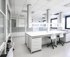 an empty office with white desks and chairs