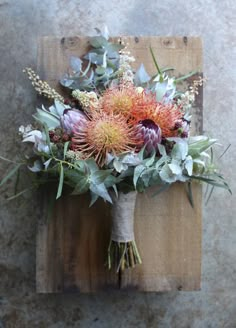 a bouquet of flowers sitting on top of a wooden board