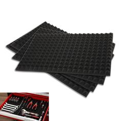 four black foam trays with tools in them on top of a wooden table next to an open tool box