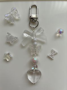 a keychain with several charms attached to it, including a heart and butterfly