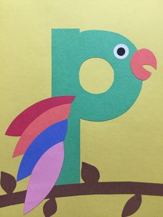 a colorful bird sitting on top of a branch with the letter p in it's beak