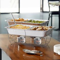 three trays of food sitting on top of a wooden table