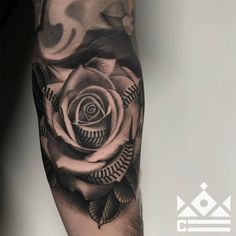 a black and white rose tattoo on the arm