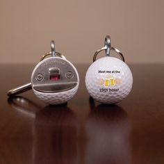 two golf ball shaped keychains on a table with the words eagle, rude, bogey and beer printed on them