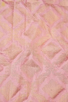 an old pink and gold cloth with designs on it