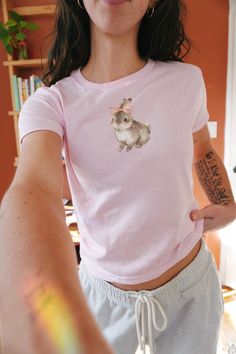 Vintage Coquette Bunny Rabbit and Bow Baby Tee 100% cotton baby tee     ✺this baby tee comes in youth sizes. this is traditional for 90's baby tee's. this is a miniaturized t-shirt different from modern crop tops. please see size chart prior to purchase ❣︎Love the vibe, but don't see exactly what you want? Send a message my way! I'd love to create something custom for you❣︎ Shop Policies: ❥ Each item is made to order. Please allow 1-7 business days for the shipping of your product.  ✺ No Returns Cute Vintage Tees, Coquette Finds, Pink Tshirt Outfit, Cute Baby Tees, Bunny Y2k, Coquette Bunny, Baby Tee Shirt, Coquette Top, Baby Tee Shirts