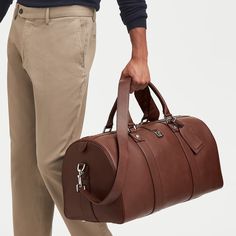 Understated and masculine, our Boston Duffle Travel Bag is the perfect companion for weekend breaks and trips to the gym. Handcrafted from the finest full-grain leather, the softly structured duffle-style shape is spacious enough for all your essentials. Designed with longevity in mind, this timeless leather travel bag has sturdy top handles and a detachable shoulder strap for superior comfort on the move. Personalisation service is available on the luggage tag. Model Man, Boston Travel, Leather Duffle, Weekend Breaks, Aspinal Of London