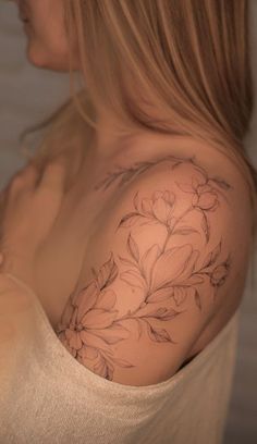 a woman with a flower tattoo on her shoulder