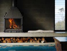 a fireplace with logs in front of it and a fire place on the other side