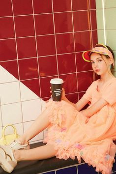 a woman sitting on a bench with a cup of coffee