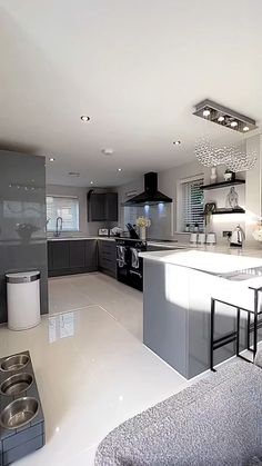 a modern kitchen with stainless steel appliances and white counter tops, along with an island in the middle