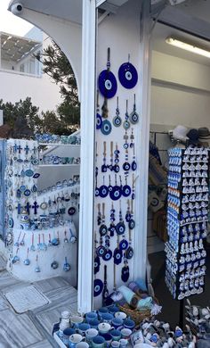 there are many blue and white items on display outside the storefront, including necklaces