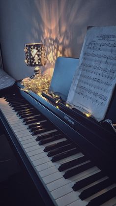 a piano with sheet music on it and a lamp next to it in a room